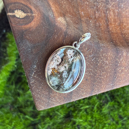 925 Silver pendant with a Garden Quartz crystal on a wooden surface